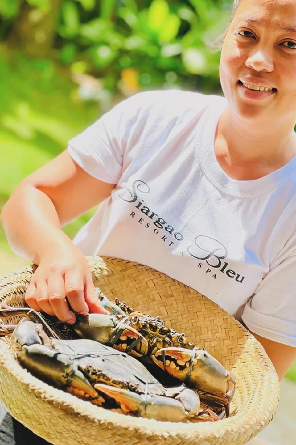 A resort team member presenting a basket of crabs