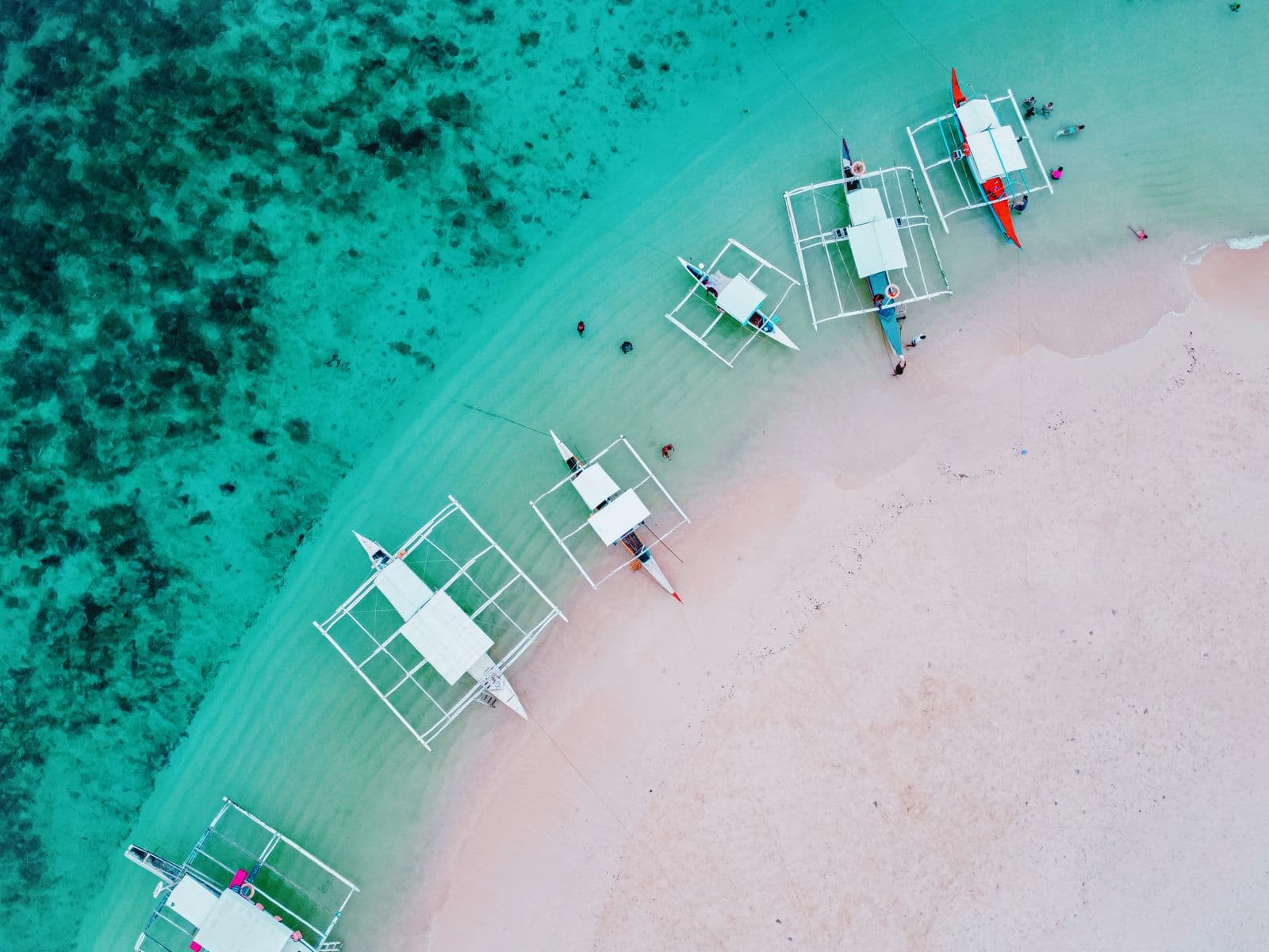 Traditional banca boats moored along the clear coast of Siargao Island