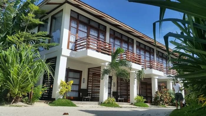 Garden Deluxe rooms framed by palms and tropical greenery